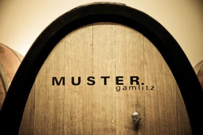 Inschrift von MUSTER.gamlitz auf großem Holzfass